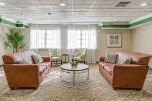Reception area with sofa facing each other and two large windows.