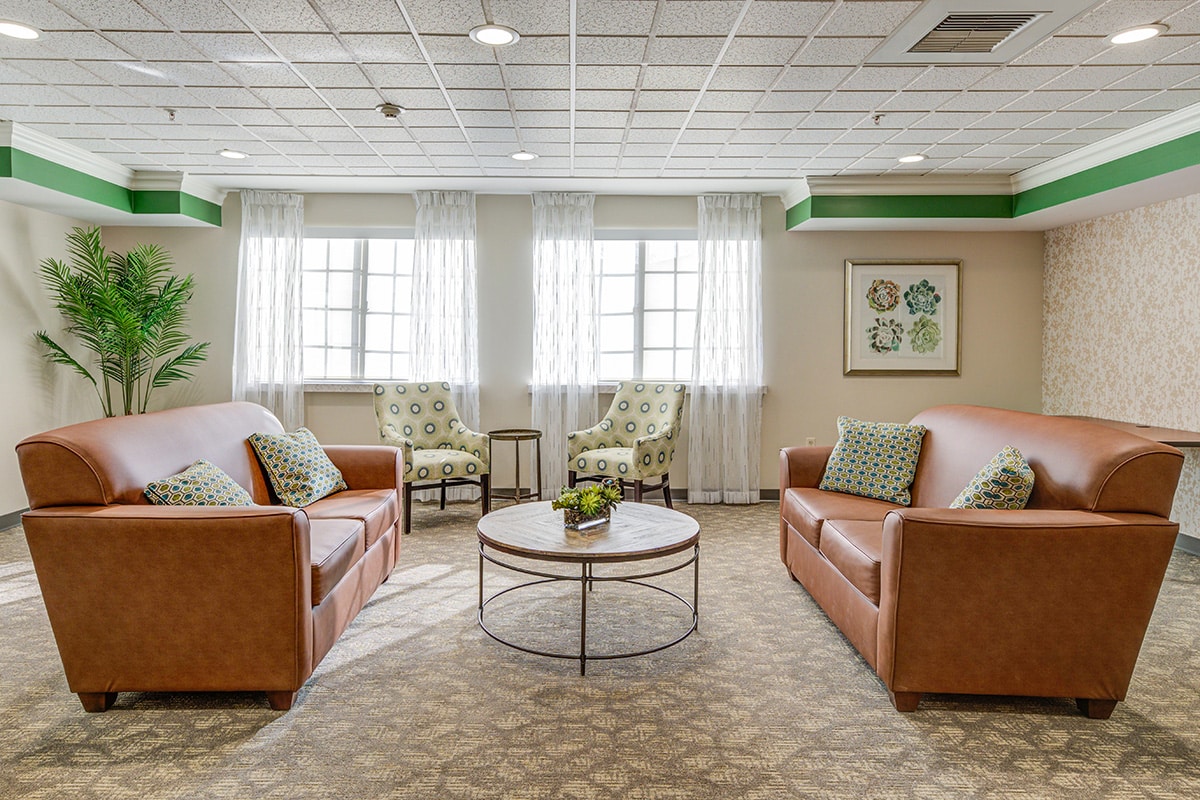 Reception area with sofa facing each other and two large windows.