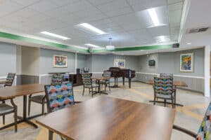 Activity room with piano, tables, and chairs