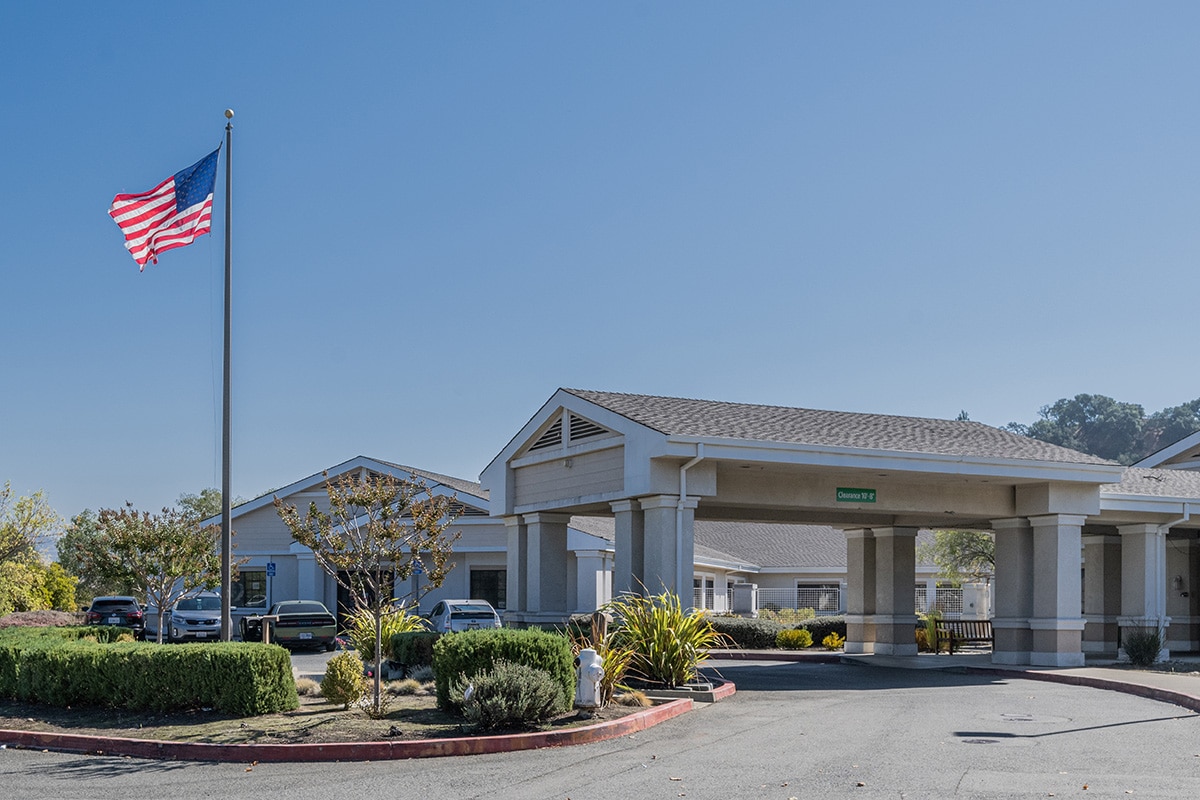 Front of facility with driveway and flag post with United States flag flying