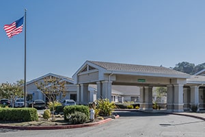 The front of the Tice Valley Post Acute facility American flag blowing in the wind