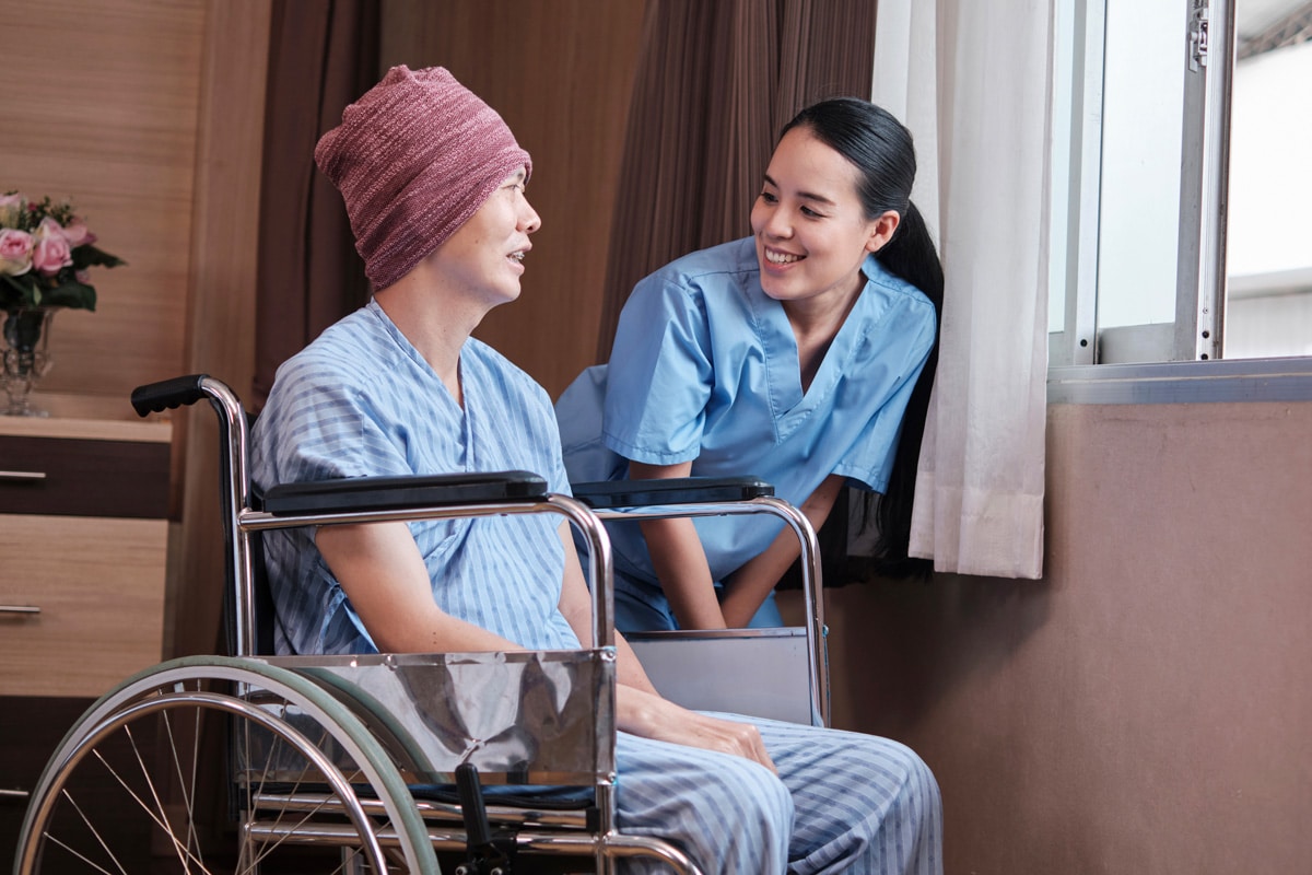 skilled nurse speaking with rehabilitation patient in wheelchair